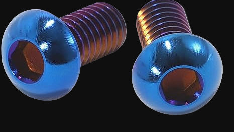 Two metallic screws with blue and copper finishes on a black background